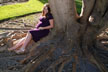pregnant wowan by tree trunk
